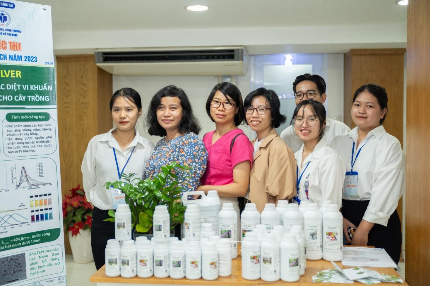 A group of people standing next to a table of white bottlesDescription automatically generated